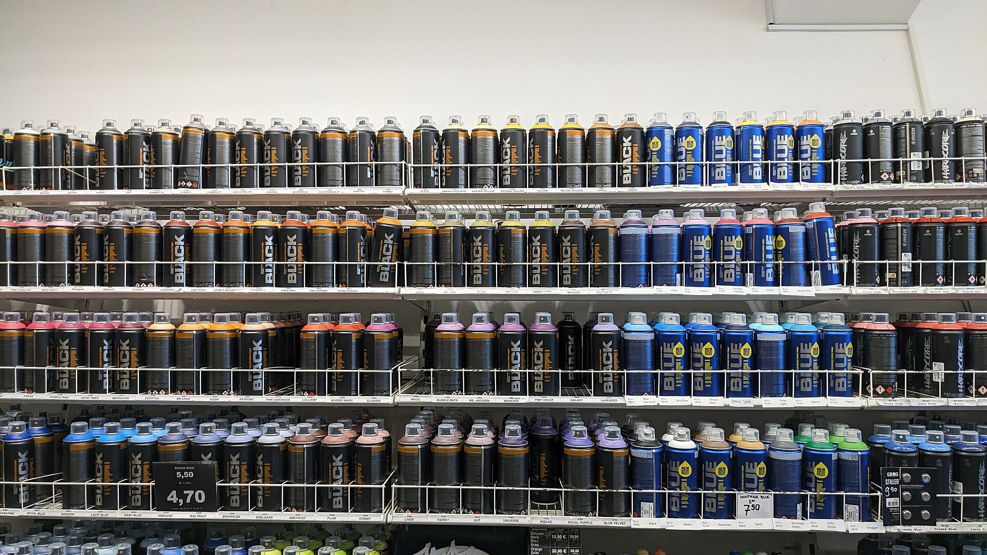 Shelves of black and blue spray paint cans in a graffiti shop